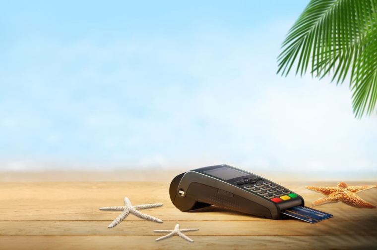 (Carte bancaire fonctionnant parfaitement et sans frais à l'autre bout du monde avec un TPE sur une plage - Crédits photo : Adobe Stock)