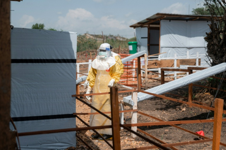 Des personnels soignants en combinaison de protection entrent dans la zone rouge du centre de traitement Ebola de l'hôpital général de référence de Rwampara, dans la province de l'Ituri, le 12 juin 2026 en RDC ( AFP / Jospin Mwisha )