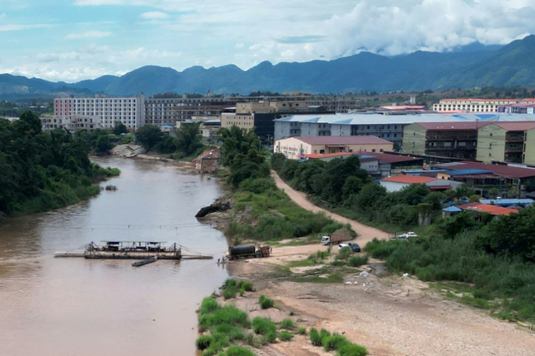 Barge traversant la rivière frontalière Moei au niveau du complexe KK Park à Myawaddy en Birmanie (à droite), photographiée depuis Mae Sot en Thaïlande, le 17 septembre 2025 ( AFP / Lillian SUWANRUMPHA )