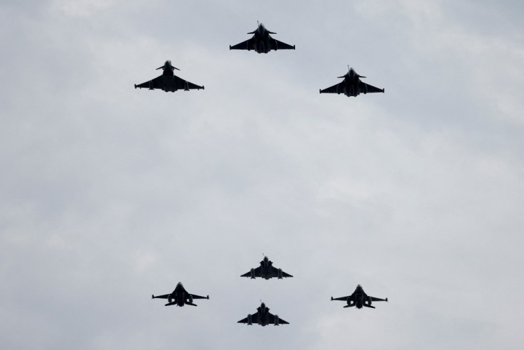 Des Eurofighter Typhoon de la Royal Air Force, des Rafale de l'Armée de l'Air et de l'Espace, un Mirage 2000-5, et un F-16 belge, dans le ciel de Paris, en 2023 ( AFP / LUDOVIC MARIN )