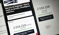 Le site de l'Assemblée nationale sur un écran de smartphone et d'ordinateur indiquant le nombre de citoyens ayant signé la pétition contre la loi Duplomb, le 28 juillet 2025 à Paris ( AFP / Thibaud MORITZ )