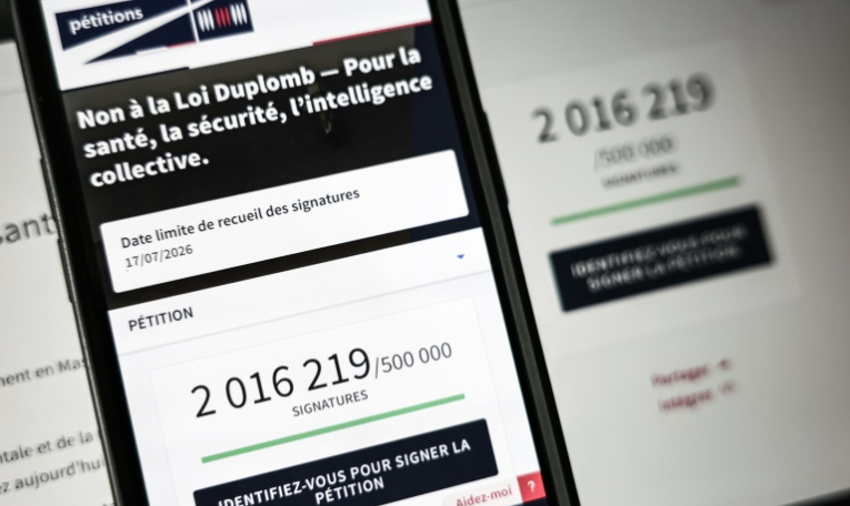 Le site de l'Assemblée nationale sur un écran de smartphone et d'ordinateur indiquant le nombre de citoyens ayant signé la pétition contre la loi Duplomb, le 28 juillet 2025 à Paris ( AFP / Thibaud MORITZ )