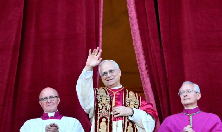 Le nouveau pape Léon XIV, l'Américain Robert Francis Prevost, salue la foule rassemblée place Saint-Pierre ) pour sa première apparition après son élection le 8 mai 2025  ( AFP / Alberto PIZZOLI )