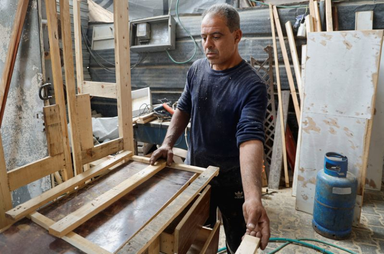 Un ouvrier palestinien construit des meubles à partir d'une palette