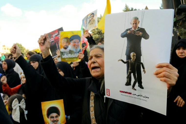 Des partisanes du Hezbollah manifestent à Beyrouth contre les négociations entre Israël et le Liban, une pancarte montre le Premier ministre israélien en train de manipuler son homologue libanais comme une marionnette, le 11 avril 2026. ( AFP / Ibrahim AMRO )