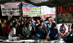 Des éleveurs tamouls installés sous une bâche pour protester contre une spoliation foncière, le 30 septembre 2026 à Batticaloa, dans l'est du Sri Lanka ( AFP / Ishara S. KODIKARA )