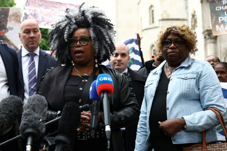 Des membres de la communauté chagossienne Bertrice Pompe (g) et Bernadette Dugasse (d) devant la Haute Cour de Londres, le 22 mai 2025, après avoir été déboutées du recours contre l'accord de restitution des îles Chagos à Maurice ( AFP / HENRY NICHOLLS )