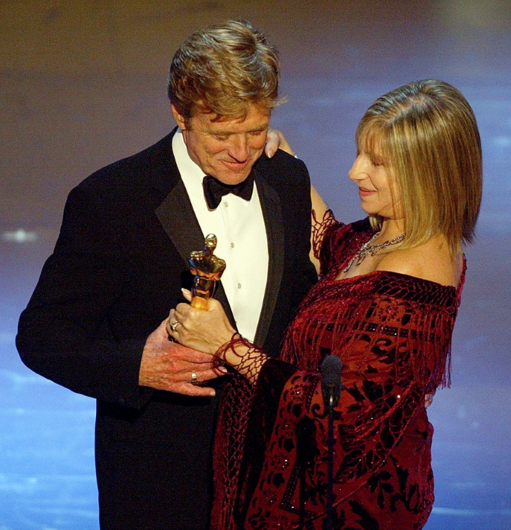 L'actrice et chanteuse américaine Barbra Streisand remet un Oscar d'honneur à l'acteur et réalisateur américain Robert Redford, le 24 mars 2002 lors de la 74e cérémonie des Oscars à Hollywood ( AFP / Timothy A. CLARY )