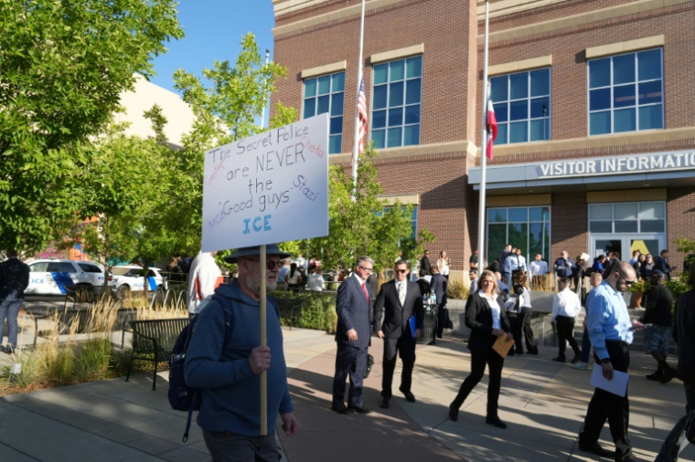 Un manifestant proteste devant une file de candidats souhaitant travailler pour la police américaine de l'immigration (ICE), à Provo, dans l'Utah, le 15 septembre 2025 ( AFP / GEORGE FREY )