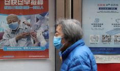 Photo d'archives d'une personne passant devant une affiche près d'un complexe résidentiel à Pékin