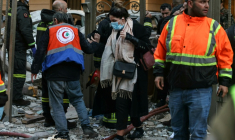 Une femme se fraie un chemin dans  les décombres d'un immeuble où des secouristes interviennent après une frappe aérienne israélienne dans le quartier d'Aïcha Bakkar à Beyrouth, le 11 mars 2026 au Liban ( AFP / IBRAHIM AMRO )