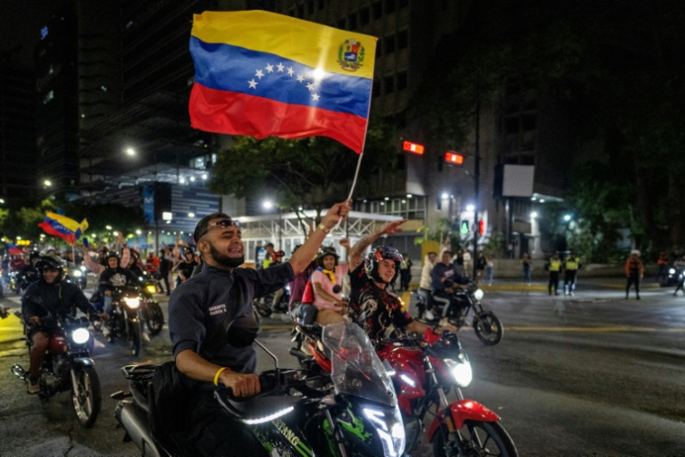 Un fan vénézuélien agite un drapeau national en célébrant la victoire de son équipe nationale de baseball en finale de la la Classique mondiale de baseball contre l’équipe des États-Unis, à Caracas, le 17 mars 2026 ( AFP / Juan BARRETO )