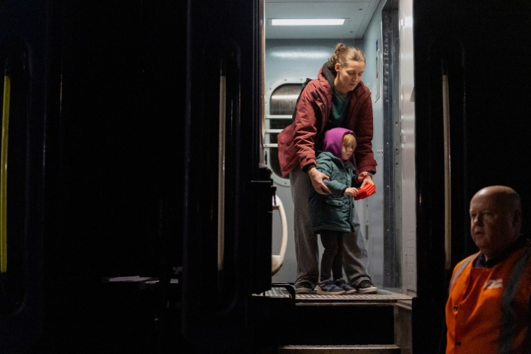 Kateryna Kumratova, spécialiste marketing de 35 ans, et sa fille de quatre ans, Nina, remontent dans le train après avoir été évacuées en raison de la menace d’un drone russe sur la ligne Kharkiv-Kiev, le 21 octobre 2026 ( AFP / Tetiana DZHAFAROVA )