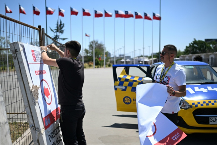Des personnes installent des panneaux dans les bureaux de vote du centre électoral du stade national Julio Martínez Prádanos, à Santiago, le 15 novembre 2025 ( AFP / MARVIN RECINOS )