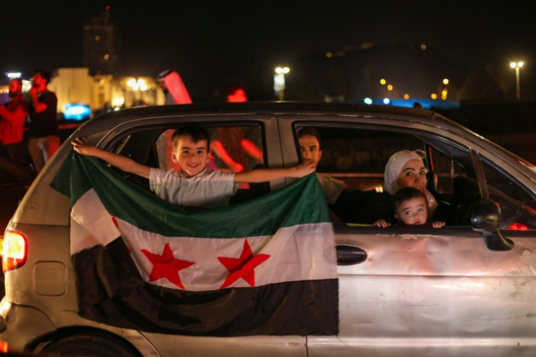 Des familles syriennes célèbrent l'annonce de Donald Trump d'une levée des sanctions américaines, le 13 mai 2025 à Damas ( AFP / Abdulaziz KETAZ )