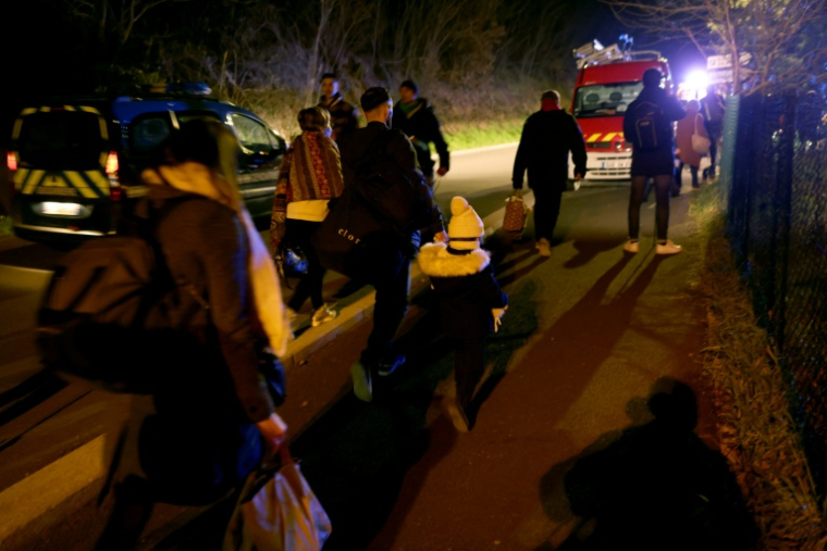 Des résidents évacuent les lieux de l'explosion, le 15 décembre 2025 à Trévoux ( AFP / Alex MARTIN )