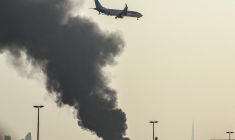 Un avion survole une panache de fumée provoqué par une frappe iranienne à Dubai, aux Émirats arabes unis, le 16 mars 2026. ( AFP / - )
