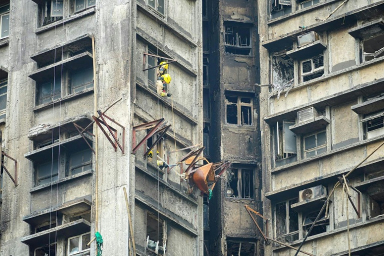 Photo diffusée par la police de Hong Kong, le 1er décembre 2025, montrant des pompiers à l'œuvre après un incendie mortel dans le complexe résidentiel Wang Fuk Court, à Hong Kong ( HONG KONG POLICE FORCE / - )