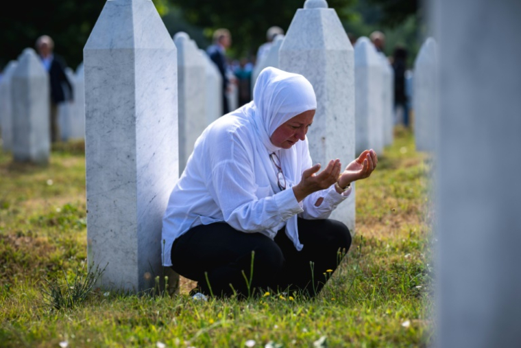 Une musulmane bosniaque prie parmi les tombes du cimetière commémoratif de Potocari, près de Srebrenica, en Bosnie orientale, le 11 juillet 2025 lors du 30e anniversaire du génocide commis par les forces serbes de Bosnie ( AFP / Andrej ISAKOVIC )