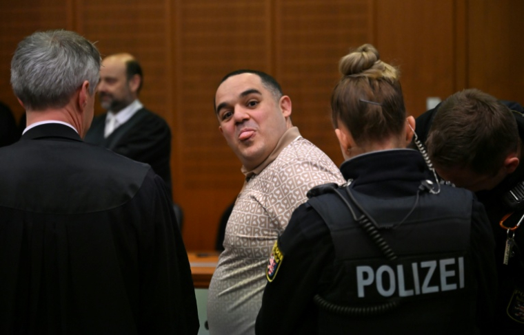 Co-defendant Ukrainian Robert A (C) sticks out his tongue as he is led into the courtroom  ( POOL / STF )