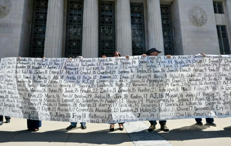 Des parents et des proches tiennent une banderole listant les noms des victimes devant la Cour supérieure de Los Angeles après le verdict du procès concernant les réseaux sociaux, le 25 mars 2026 en Californie ( AFP / Frederic J. Brown )