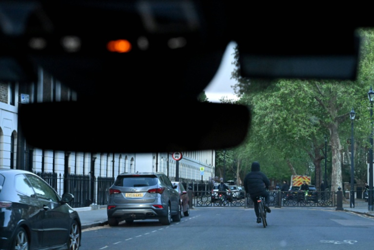 Un suspect sur un vélo électrique vu d'une voiture de police, à Londres, le 25 avril 2026 ( AFP / Ben STANSALL )