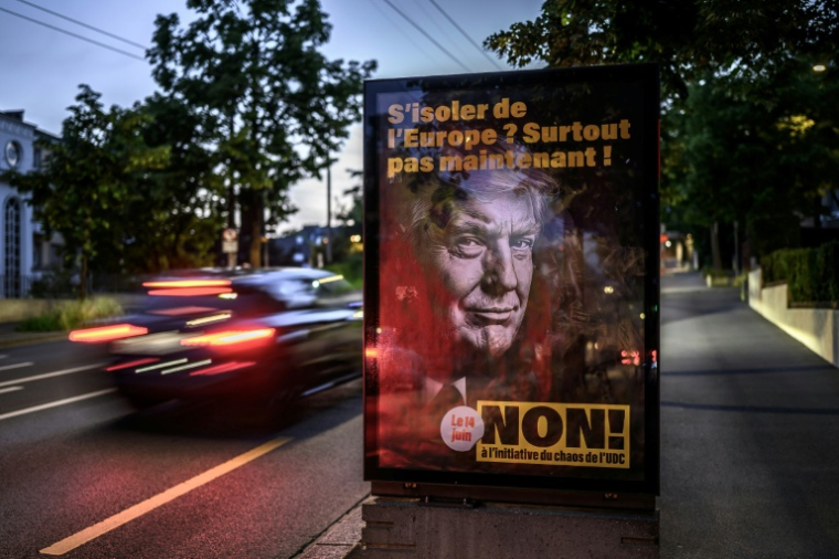 Une affiche électorale s'opposant à une initiative visant à plafonner la population à 10 millions d'habitants, représentant le président américain Donald Trump et portant l'inscription en français "S'isoler de l'Europe ? Certainement pas maintenant !", à Lausanne, le 25 mai 2026 en Suisse ( AFP / Fabrice COFFRINI )