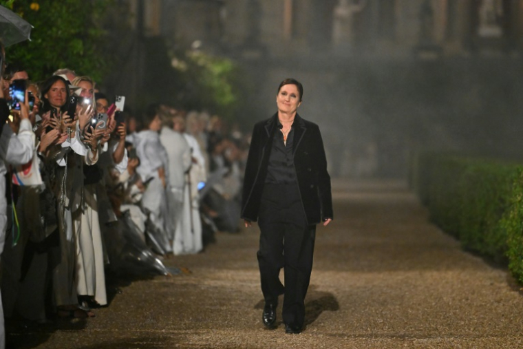 Maria Grazia Chiuri (c), directrice artistique de Dior, salue le public à la fin du défilé de la collection Dior Femme Croisière 26 à la Villa Albani Torlonia, à Rome, le 27 mai 2025 ( AFP / Andreas SOLARO )