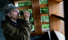 L'ornithologue belge Alain Malengreau observe des oiseaux depuis une cabane dans les marais d'Harchies, une zone naturelle protégée belge, le 21 août 2026 à Bernissart dans le sud-ouest du pays ( AFP / Sameer Al-DOUMY )