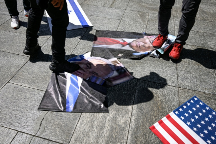 Des manifestants piétinent des photos du président américain Donald Trump et du Premier ministre israélien Benjamin Netanyahu, le 24 juillet 2026 à Caracas ( AFP / Maxwell BRICENO )
