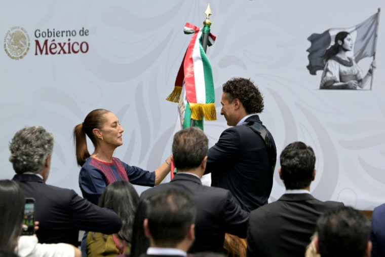 La présidente Claudia Sheinbaum remet le drapeau national au gardien de but Guillermo Ochoa, lors d'une cérémonie en l'honneur de l'équipe nationale de football du Mexique avant la Coupe du monde de la Fifa, le 8 juin 2026 à Mexico ( AFP / Alfredo ESTRELLA )