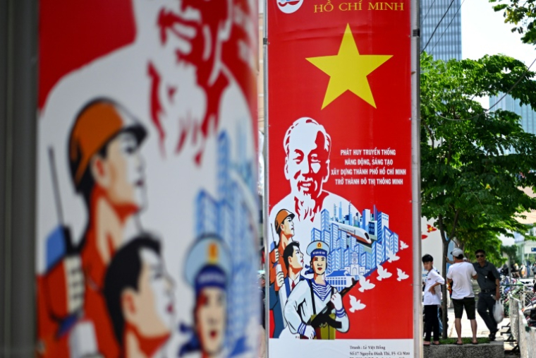 Des affiches commémorant le 50e anniversaire de la fin de la guerre du Vietnam dans une rue à Ho Chi Minh Ville, le 29 avril 2025 ( AFP / MANAN VATSYAYANA )