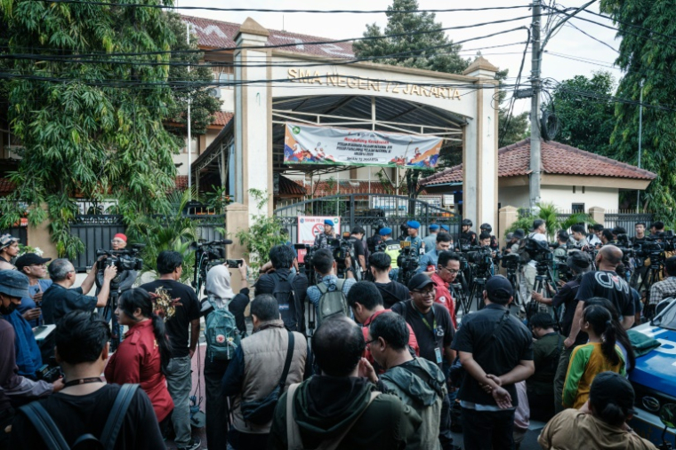 Des journalistes devant l'entrée d'un établissement scolaire à Jakarta le 7 novembre 2025 ( AFP / YASUYOSHI CHIBA )
