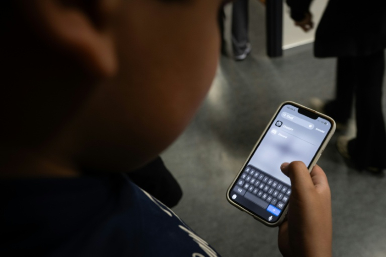 Un élève consulte l'application ChatGPT sur son téléphone après un cours d'intelligence artificielle (IA) au collège Jean Mace à Mulhouse, le 26 mars 2026 dans le Haut-Rhin ( AFP / SEBASTIEN BOZON )