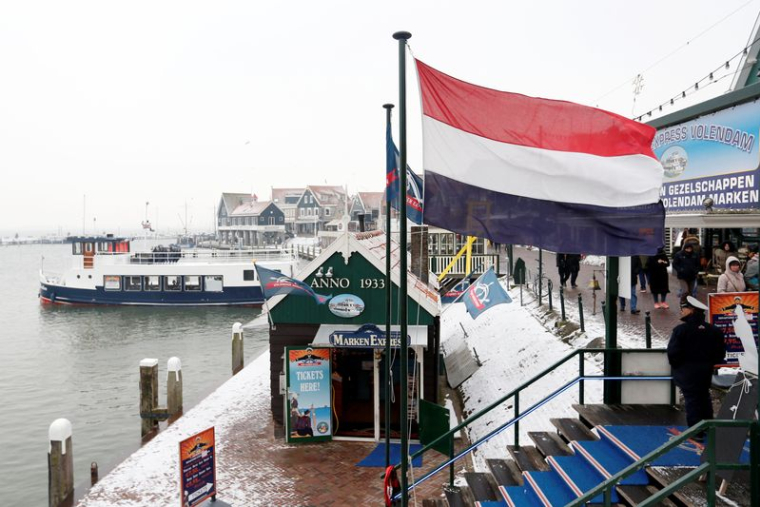 Un drapeau néerlandais flotte dans le port de Volendam près d'Amsterdam