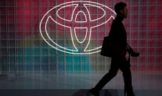 Un homme passe devant un logo Toyota à Tokyo