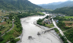 Un pont en partie détruit au-dessus de la rivière Trishuli après la crue destructrice dans l'Himalaya, le 30 août 2026 dans le district népalais de Dhading ( AFP / Manan VATSYAYANA )