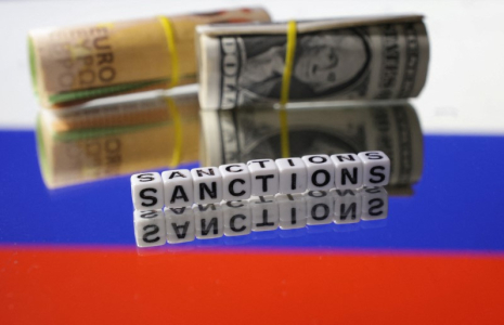 Billets de banque en euros et en dollars et mots "Sanctions" sur le drapeau russe