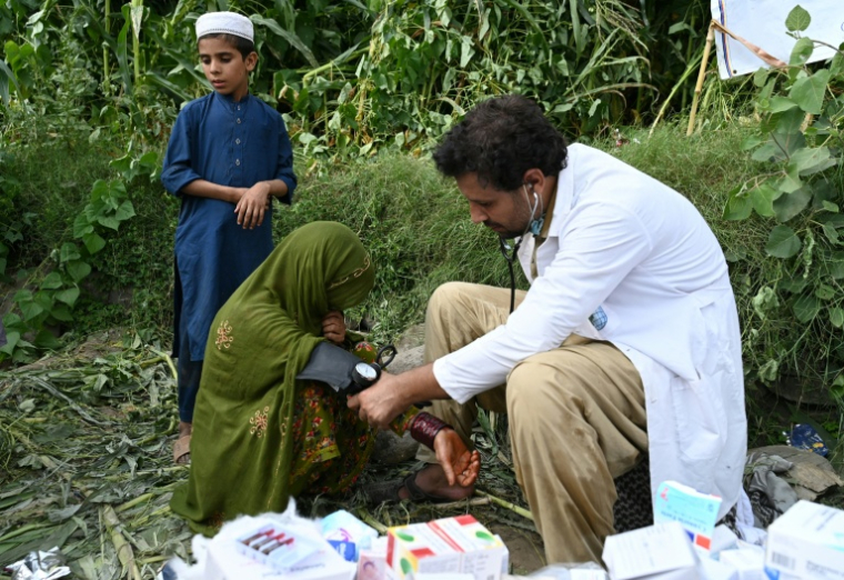 Une femme afghane blessée reçoit des soins médicaux devant une maison endommagée après des tremblements de terre dans le village de Mazar Dara du district de Nurgal, dans la province de Kunar, en Afghanistan oriental, le 1er septembre 2025 ( AFP / Wakil Kohsar )
