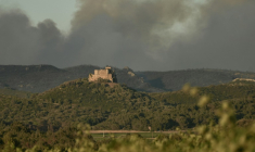 De la fumée s'élève derrière le château de Saint-Martin-de-Toques, près de Narbonne le 7 juillet 2025 ( AFP / IDRISS BIGOU-GILLES )