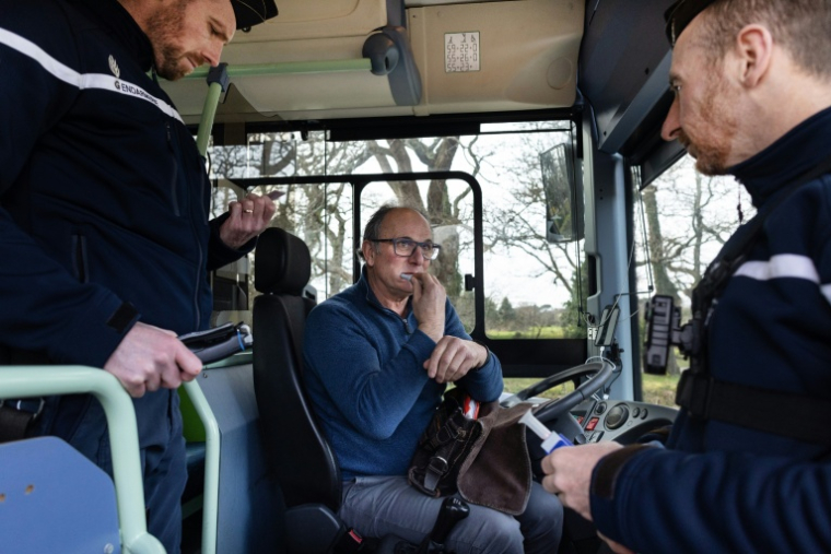 Un chauffeur de bus scolaire effectue un test salivaire lors d'un contrôle routier de gendarmerie à Auray, dans le Morbihan, le 6 février 2025 ( AFP / FRED TANNEAU )