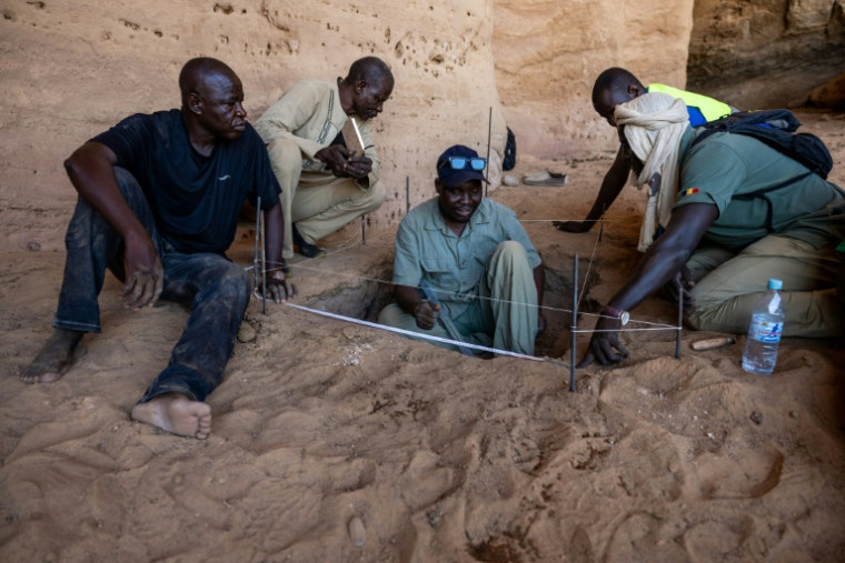 Djimet Guemona, archéologue, au centre sur l'image, lors de fouilles à Garoa Hallagana, dans l'Ennedi-Ouest, au Tchad, le 10 juillet 2025 ( AFP / Joris Bolomey )