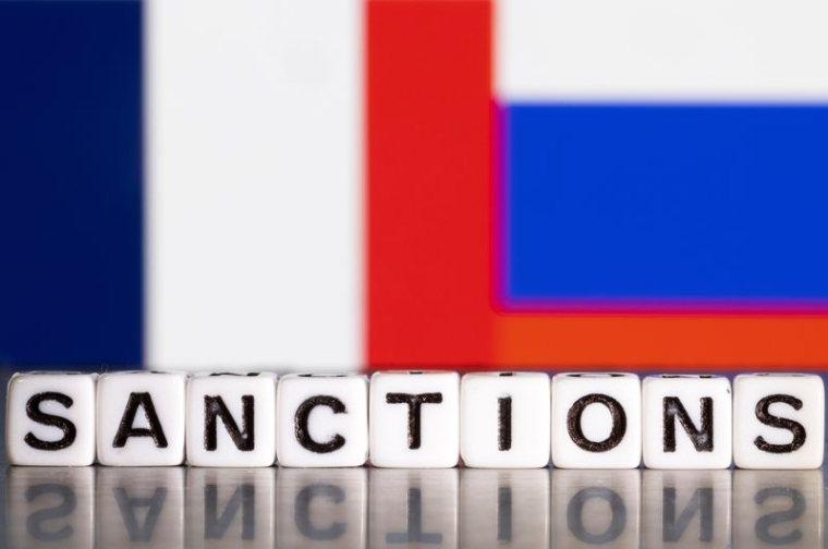 L'illustration montre des lettres disposées de manière à lire « Sanctions » devant les couleurs des drapeaux de la France et de la Russie.