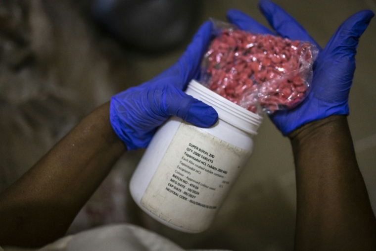 Un agent montre des comprimés rouges de tapentadol dans les locaux de l'Agence nationale de lutte contre la drogue (NDLEA) à Lagos, le 19 février 2026 au Nigeria ( AFP / OLYMPIA DE MAISMONT )