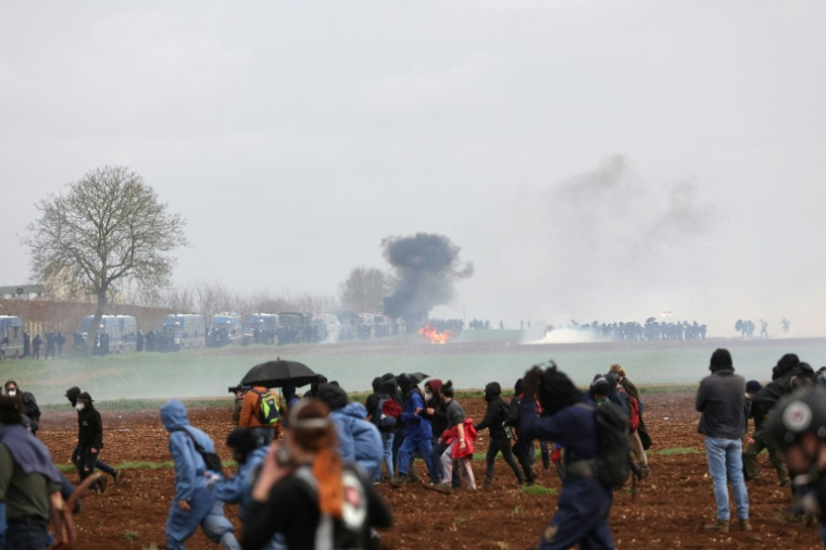 Des manifestants affrontent des gendarmes mobiles anti-émeute lors d'un rassemblement à l'appel du collectif "Bassines non merci", du mouvement écologiste "Les Soulevements de la Terre" et du syndicat "Confédération paysanne" contre la construction d'une nouvelle réserve d'eau pour l'irrigation agricole, à Sainte-Soline, le 25 mars 2023 dans les Deux-Sèvres ( AFP / Thibaud MORITZ )