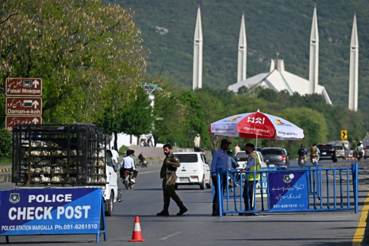 Des membres des forces de sécurité montent la garde le long d'une route temporairement fermée en prévision des pourparlers de paix américano-iranien, le 20 avril 2026 à Islamabad, au Pakistan  ( AFP / Aamir QURESHI )