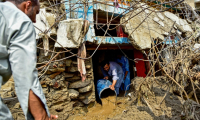 Un homme retire la boue de l'intérieur d'une maison après les crues subites dans la province montagneuse de Khyber Pakhtunkhwa au Pakistan le 16 août 2025 ( AFP / Hasham AHMED )