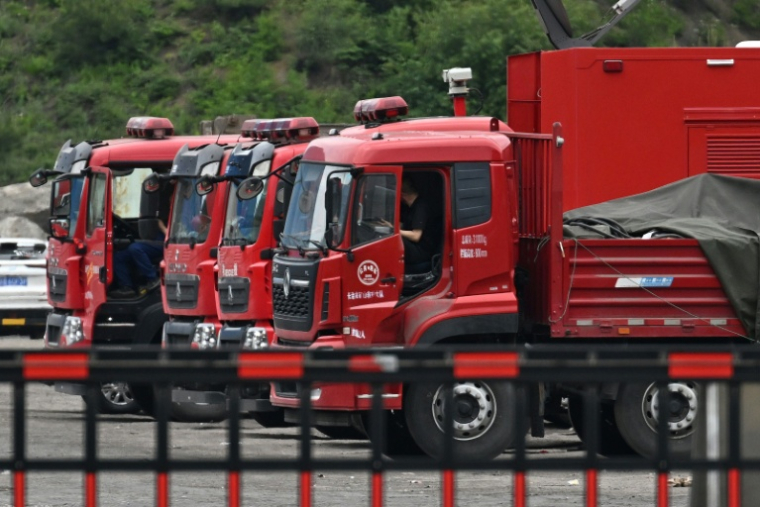 Des véhicules de secours stationnés devant l'entrée de la mine de charbon de Liushenyu, où un coup de grisou dévastateur a fait au moins 82 morts, le 24 mai 2026 dans le district administratif de Qinyuan, dans la province chinoise septentrionale du Shanxi ( AFP / GREG BAKER )
