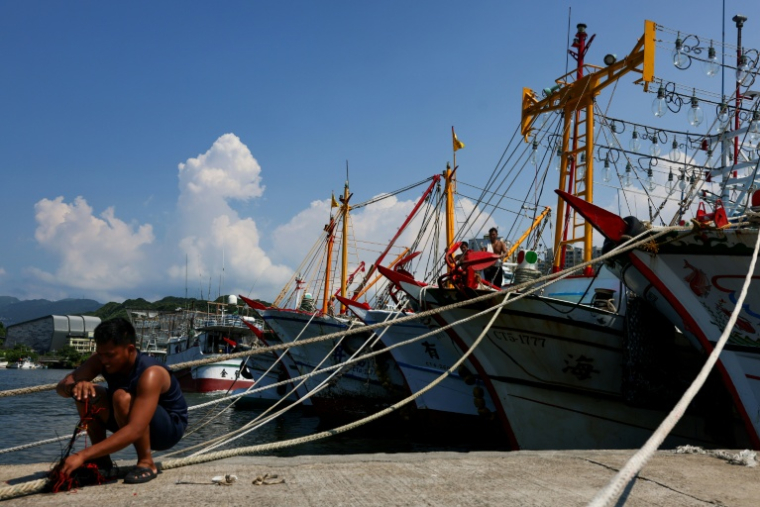 Un pêcheur sécurise les amarres de son bateau avant l'arrivée  du typhon Bavi à Keelung, le 8 juillet 2026 dans le nord-est de Taïwan ( AFP / I-Hwa Cheng )