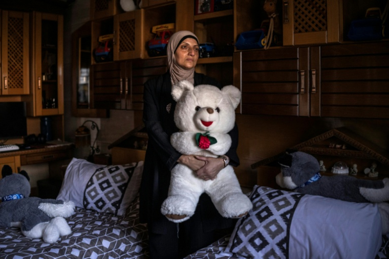 Kholoud Mamadneh, la mère de Mahmoud, tué à 15 ans par un soldat israélien alors qu'il rentrait de l'école, tient la peluche de son fils, à Jénine, le 27 juillet 2026 ( AFP / JOHN WESSELS )
